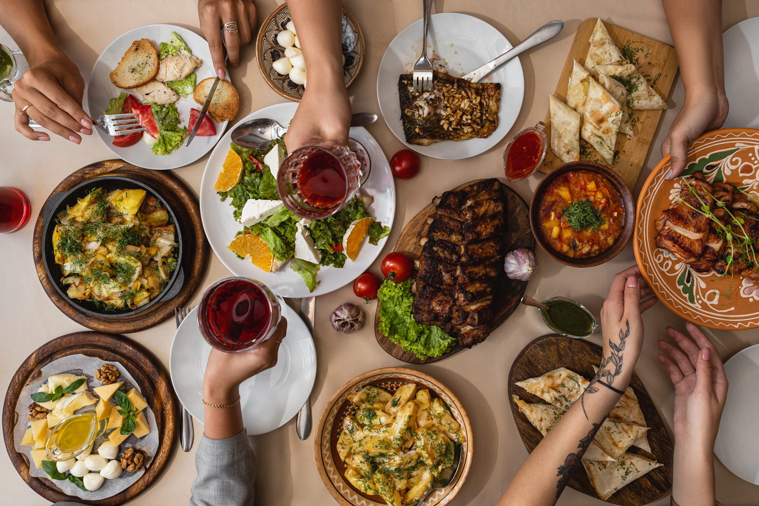 wide and tasty table covered with delicious Ukrainian cuisine on which sits a large family or friends their hands at the table during meals Produkte für die Küche spanischer Restaurants online bestellen